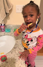 Load image into Gallery viewer, African amerian girl in pink Minnie Mouse pajamas brushing her teeth at the bathroom sink with the help of an original toothbrush timer.