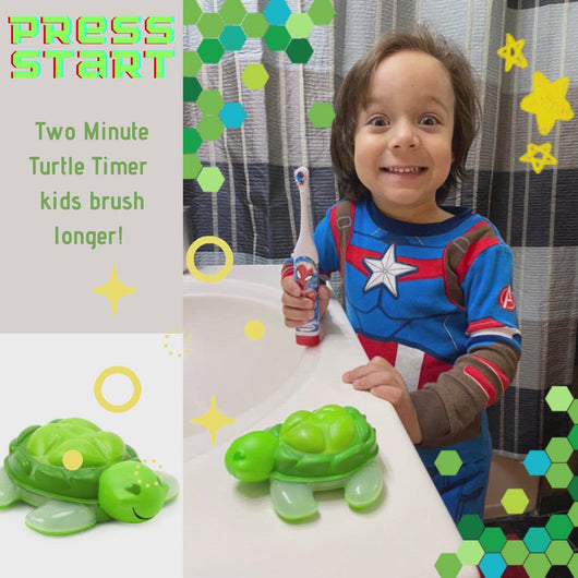 smiling boy in pajamas holding toothbrush with green turtle timer on bathroom counter 